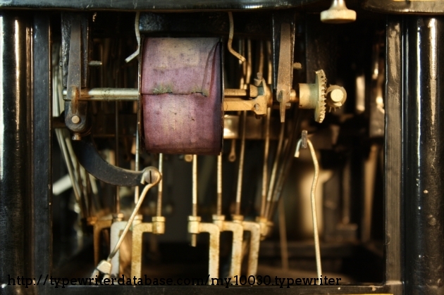 The big faded ribbon sits coiled on the right spool, amidst hooks and rods everywhere. This ribbon has since been replaced, and I accidentally destroyed the little ribbon tags that the main ribbon is pinned onto because the pin had disintegrated and I didn't realize that was the attachment point.