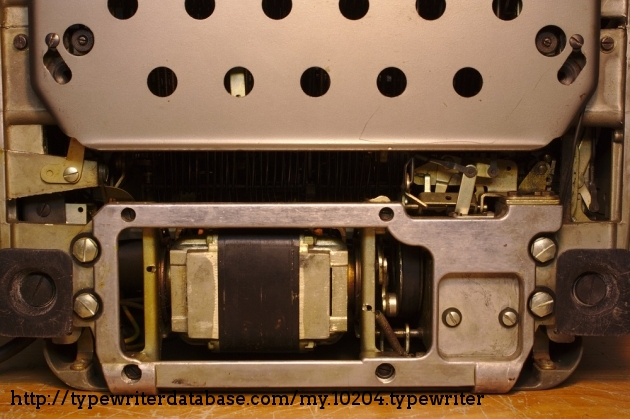 A big motor for a big standard; it gets hot during operation, as they all do.

There are two thick rails at the bottom of the back (barely visible here) to allow the typewriter to be tilted backwards like this without damaging the backplate.