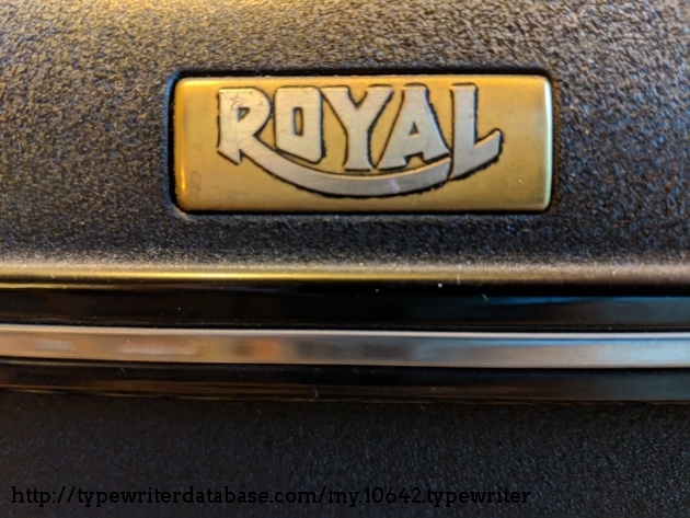 Detail of gold nameplate / head-badge with accent trim.