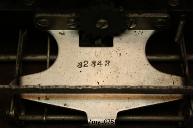 This machine and its brethren actually have two serial numbers. On this particular model, the first is stamped here on part of the escapement frame.