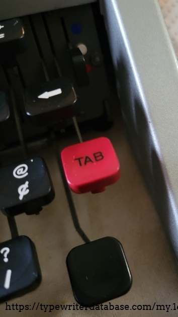 Red tab key and ribbon selector lever.