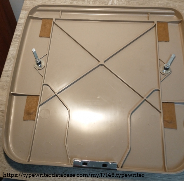 Bottom plate with new rubber hose (fuel hose, OD 10 mm, ID 5 mm) and felt patches where the feet of the typewriter rest in the bottom plate