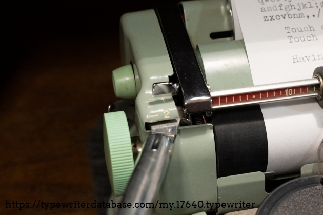 Line spacing setting. Free, 1 line, 1.5 lines, 2 lines. The smaller green button behind the platen knob is the left carriage release. You can also see some of the Hermes ribbon-based margin indicator system on the paper bail.