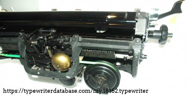 the carriage assembly. You see the stationary frame with a few of the many tab-stops, the bell  and the clock-type spring. The pull-cord is green for reasons of lust in deviating from the obvious
