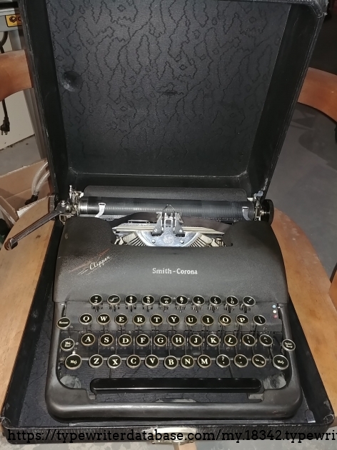 The airplane decal of  a Boeing B-314 features prominently on the ribbon cover, surely to reaffirm the lightness and portability of this machine.  

The rubbed off paint on the cover is a witness to how many times a left hand pushed the carriage return lever and hit the cover at the same time.