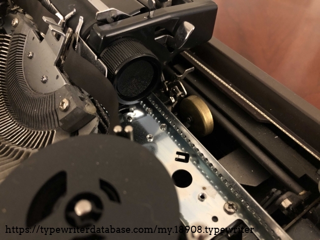The bell on this typewriter is quite loud for it's small size-- produces a quite pleasing tone. It is located below the carriage, near the right ribbon spool.