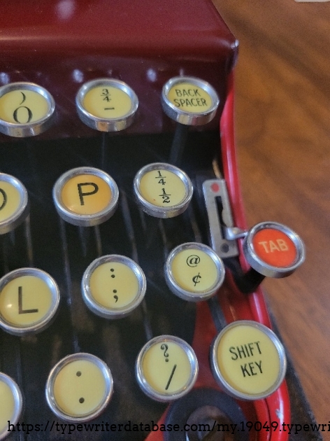 Close up of right keys - one red tab key, 3/4 fraction key, and the ribbon selector.