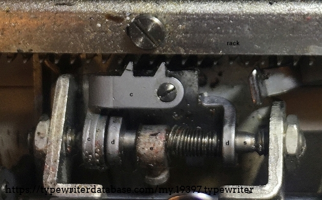 When the spacebar or any key is pushed down by the typist, the cycle begins. The action is described here in slow-motion.  At first,  the spacebar sinks the bracket’s two teeth down to engage into the rack from the top. Since the teeth of the bracket and the catch are aligned, there is hardly any force needed. Now the bracket is doing what the catch was doing until now: prevent the carriage to move under the tension of the spring motor.
When depressing the space bar further, the bracket is moving down further, and pushing the catch’s teeth out of engagement with the rack, freeing them up below the rack. Now the catch does its trick: under the influence of the spring, it jumps to the right against its stop (st). And, as far as it can, the catch turns its two teeth up behind the rack’s tooth that it was blocking before. All this thanks to the little spring on the arbour (s). 
We are not done with the slow-motion action: we have yet to release the spacebar. 
The spring motor is pulling the carriage to the left as it always does. The carriage did mot move yet since the bracket is securing it in place. 
When the typist lets the spacebar come up, the escapement bracket will lift its two teeth out of engagement with the rack’s teeth. Now the carriage starts moving to the left. The catch was already behind the next tooth of the rack, or it will soon be, now that the rack starts to move left, which fully opens a gap for the catch to engage before the next tooth of the rack. With the catch engaged, the carriage will move further to the left but it will not get very far: after 2,2 mm pitch of the racks teeth, the catch will hit the brackets side wall, the bracket will stop the carriage before it gains any speed. 

Sigh. The carriage travelled 2,2 mm and it took 300 words to describe the voyage. That is 7 micron per word, truly a slow motion….

In the original machine at hand, the stop (e) allowed the catch to move 2,4 mm to the right. After readjusting the stroke to 1 mm it still works fine. We do not see a reason to have a larger gap.

On the photo in the right upper corner you see the hook that is waiting to reach into the gear rack if a backspace action is called upon.