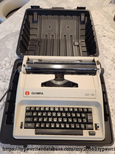 1984 Olympia CE-12 electric typewriter front view in moulded plastic case