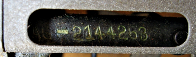 Move the carriage all the way to the right to find a little window filled with eraser crumbs, under which is the serial number. (The AG- prefix is in the shadow at left.)