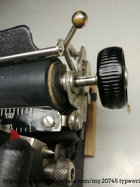 Showing a little bit of the wooden platen core on the rightmost side. This platen rubber has obviously been changed since 1929 as it is soft enough to type on.  The plating on the little brass ball end of the paper release lever has worn from years of use.
