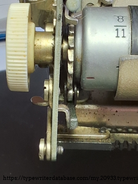 Close-up of the left side of the platen, with the ratchet wheel and line location roller.