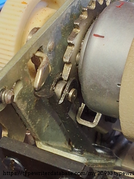Underside of the ratchet wheel, showing thecleaf spring and the roller that clicks to hold the line location.