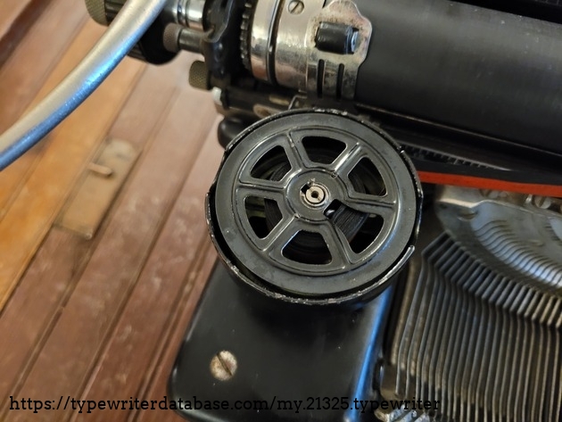 The spools of this typewriter are not universal.  The odd shaped hole in the top is part of the ribbon reversing mechanism.  When the ribbon is no longer wound around a little tab, it falls out, and allows for the ribbon to be automatically reversed on the next keystroke.  I used the ribbon from a universal ribbon, and just attached it to the custom spools.  It works fine.