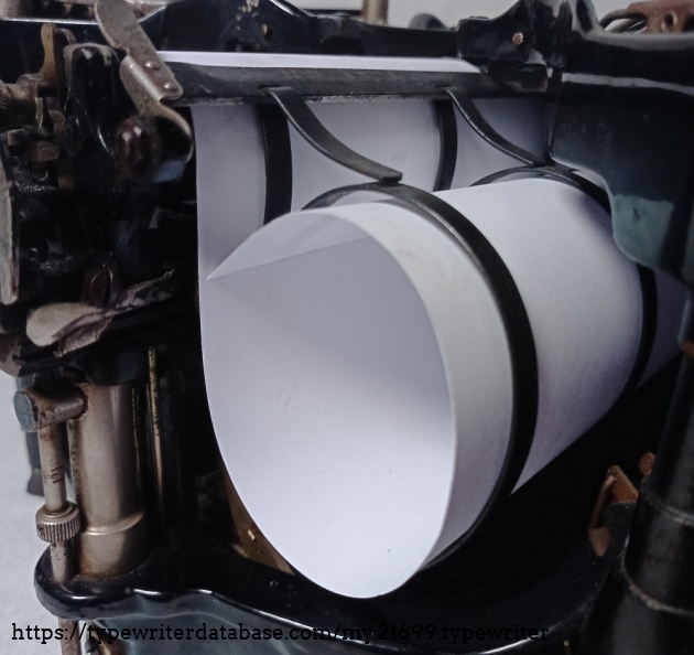 The paper is rolled into these wire baskets. It is then guided over the roller during writing and then Letter rolled back into the second wire basket