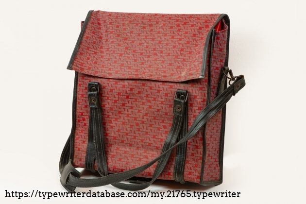 The best thing of this typewriter is the bag.
There is a detachable shoulder strap with a central reinforcement for greater comfort during transport.
The colour is red, and there is Olivetti written all over it.
It is closed with Velcro. 
And two handles for normal carrying, with a tie to keep them together.
There is a big attention to the details.
On the bottom there are 4 metal feet, and an internal plate, so you can place it on the floor, and it stays upright.
I think could be a high fashion item.