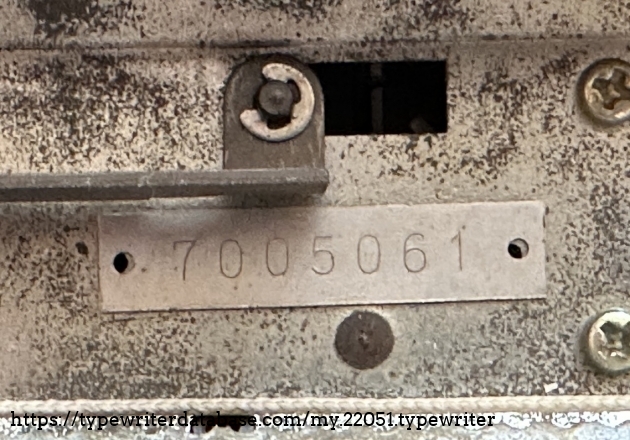 Serial number plate located under carriage. Interestingly, the nameplate and carriage rail seem to have holes so that the plate can be fixed with screws, but instead it seems to have been stuck down with glue.
