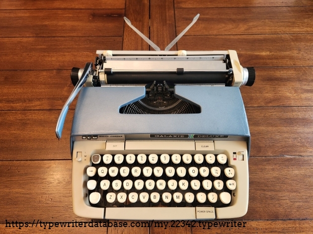 Typewriter with two thin metal arms extended at the back. They would be used to hold up a sheet of paper.