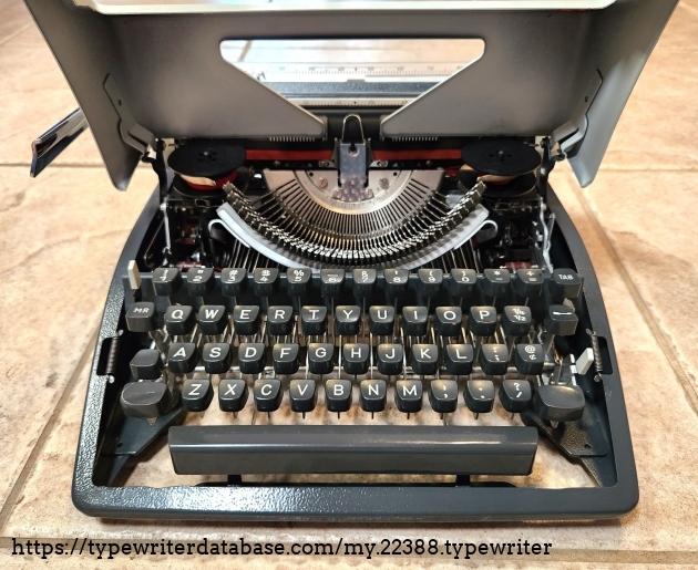 Note the flip-up top. Remove the two circlips and four screws inside the feet and the entire typewriter comes out of the case for service and cleaning.