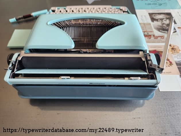 Angled view from the back of a Remington Streamliner typewriter featuring the carriage return, platen, and a view into to the typebasket.