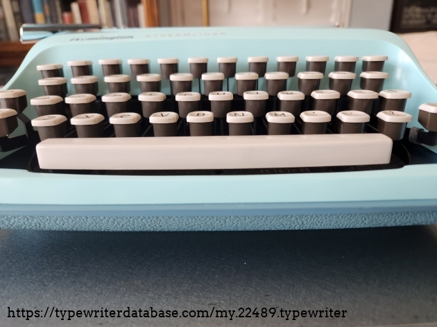 A desktop view of the edges of the Remington Streamliner keyboard showing the top layer of cream and the bottom of their bodies in dark brown.