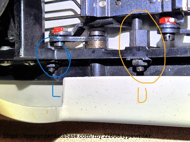 Here's the upper and lower case adjustments I mentioned. You can clearly see the positioning stud inside the yellow circle. The rear of the machine is to the right on this photo and the screws are not accessible without taking the cover off. (But you don't have to remove the bottom place.)