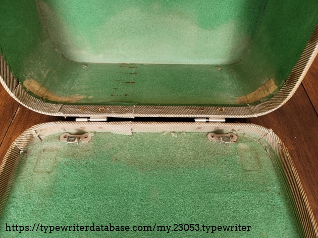 Close up of the stained and aged green interior of a 1949 typewriter case.