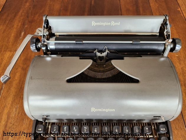 Close up of the hood and carriage of a Remington All-New typewriter. Crisp Remington logo is featured on the hood.
