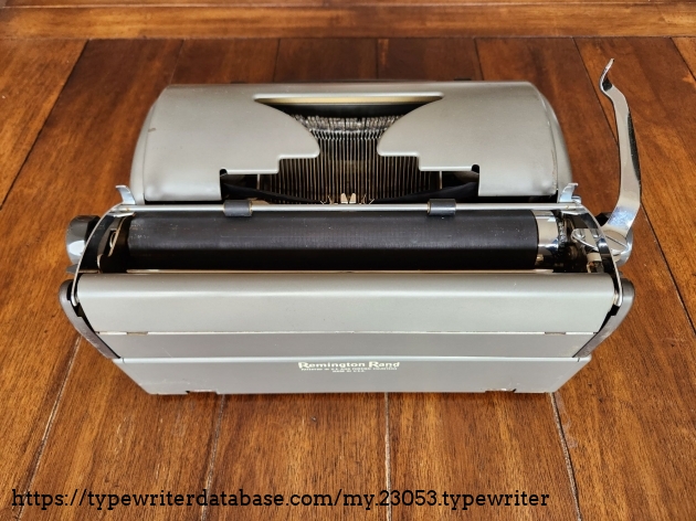 Angle down onto the rear of a Remington All-New typewriter with a shadowed view into the typebasket and the typeface.