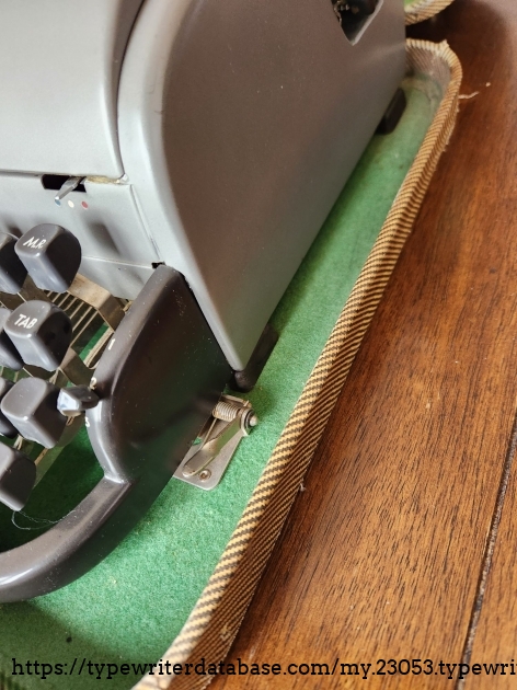 Close up of the metal clamp fitting that locks the Remington All-New typewriter into its case.