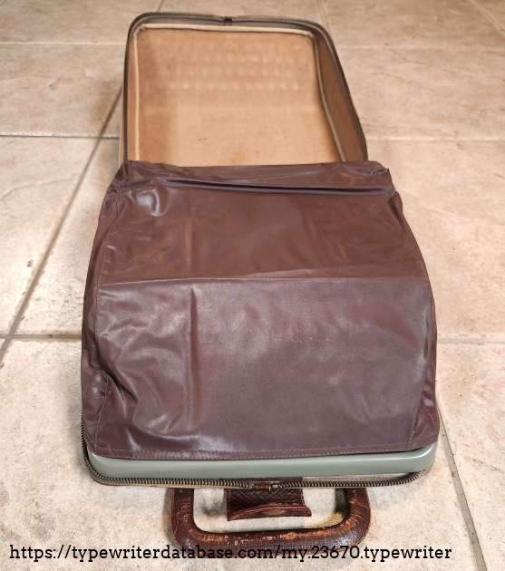 The original vinyl dust cover, used when the typewriter is out of its case. It doesn't quite fit now, but it is otherwise completely undamaged.