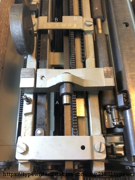 The stationary part of the carriage assembly . At A the pin that is locked in the carriage lock. At B the handwritten serial number. At C the bell.