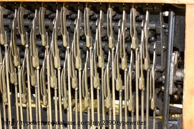 This photo is taken from under the keyboard.
The keypoard doesn't run on pivot rods, but on pulling rods. This leverage system is very similar to the one used on the Smith Premier 10 and requires few moving parts comparing to the Olivetti M1 system.