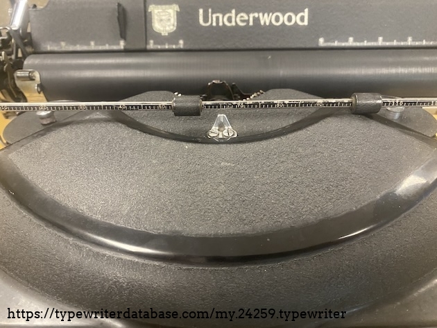 Did you know that the little "gun-sight" looking thing on the  top cover of the typewriter is meant to be used like this? There isn't a cursor arrow to show your typing position, so if you want to check, you can flip back the paper bail so it lines up with the sight and shows you your position.