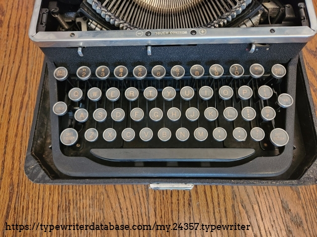 Close up on the glass keys and keyboard of a 1939 Royal Aristocrat typewriter. The paper legends are black backgrounds with yellow letters.