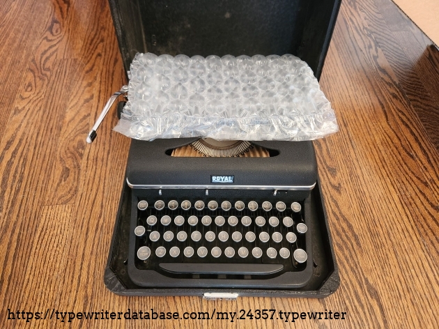 A sheet of bubble wrap protects the top of a 1939 Royal Aristocrat typewriter. Inside the typebasket we can see a small sheet of cardboard to protect the slugs during shipment