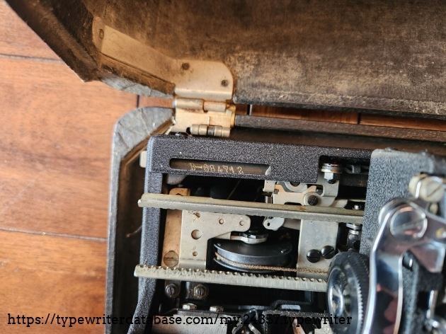 View into the left rear corner of a 1939 Royal Aristocrat typewriter with the carriage moved to the right. We see the serial number in the leftmost corner.