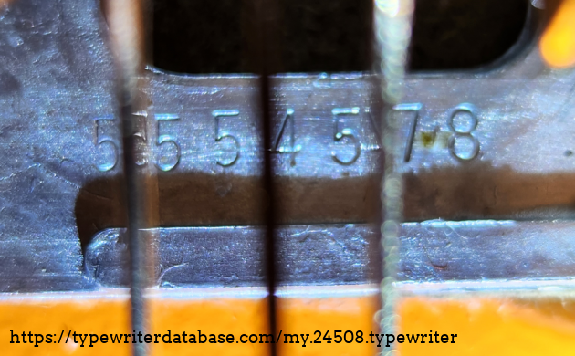 Serial number 5554578, located on the base plate, visible by looking directly down between the top two rows of keys on the right-hand side of the keyboard. (The lines in this photo are the key levers above the serial number.)