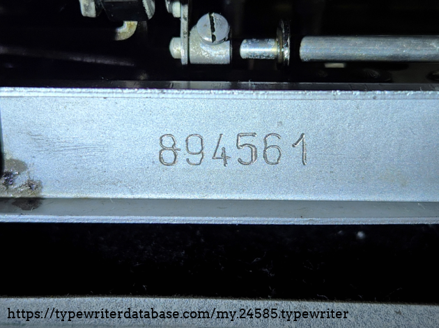 Serial number 894561. Located beneath the typewriter on the rear support bracket. Notice that, while this was very well done, it looks like it was put on with an electro-pen.