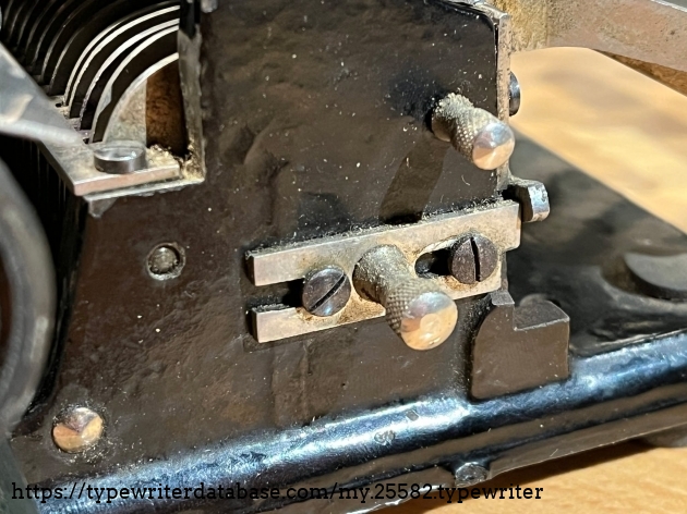The upper knurled thumb screw locks out the shift key for figures on the third row of standard typewheels--essential for the two row telegraph typewheel. The upper knurled thumb screw locks out the shift key for figures on the third row of standard typewheels--essential for the two row telegraph typewheel.