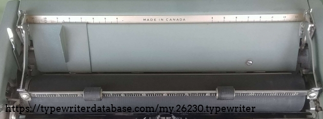The scale on the table is convenient for centering the sheet of paper while the scale on the paper bail is the same as on the front margin scale. In addition, the paper bail can be pulled forward or lifted. The scale on the table is convenient for centering the sheet of paper while the scale on the paper bail is the same as on the front margin scale. In addition, the paper bail can be pulled forward or lifted.