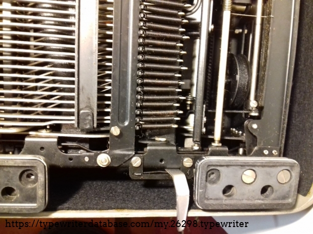 Carriage lock system on the left side, under the machine