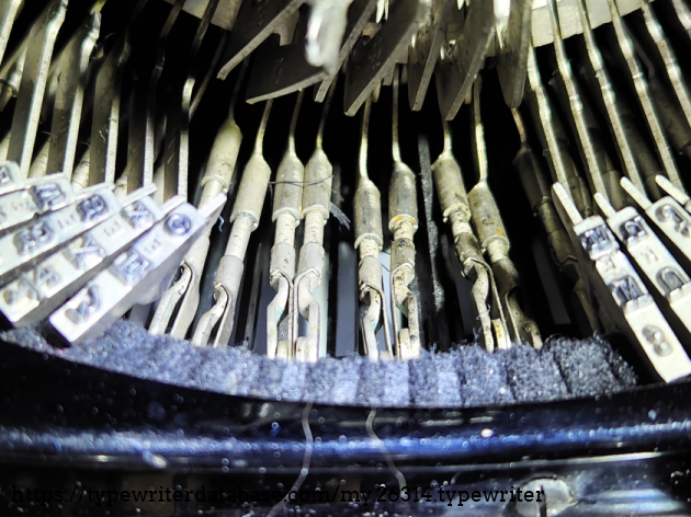 Note the adjustable clevis heads on the threaded rod. As far as I am aware, this is the only typewriter to ever use this system for type bar linkages. Note the adjustable clevis heads on the threaded rod. As far as I am aware, this is the only typewriter to ever use this system for type bar linkages.