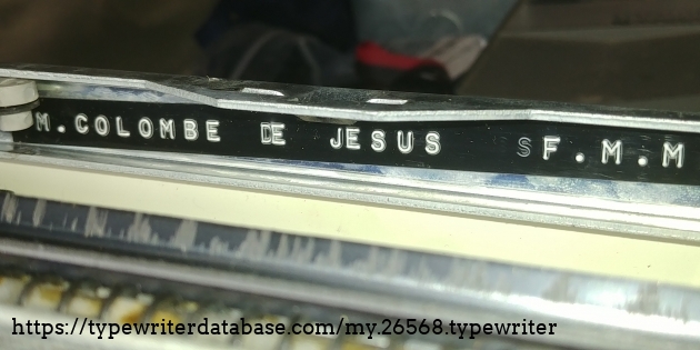 Clever place to stick your name!  It's up side down, inside the frame, below and in front of the space bar. 
It might be Michelle Colombe de J&eacute;sus F.M.M. (Franciscaine missionnaire de Marie).