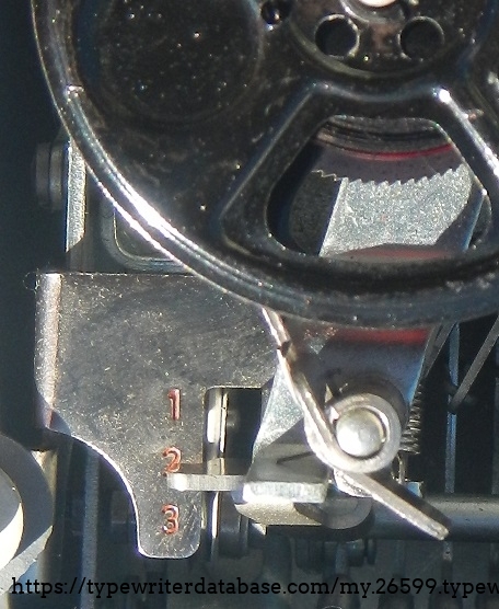 The touch selection lever, under the ribbon cover, beside the left ribbon spool.
