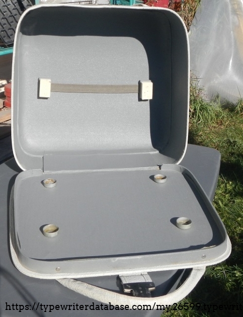 The inside of the case.  The feet fit into the little fixed cups at the bottom.  The elastic strap could be used to store a few papers or whatnot.  The original manual and a small 'cleaning kit' are long gone.