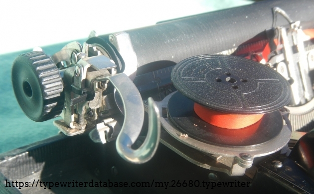 The small black zip-tie that's holding the carriage return lever up so that it doesn't collide with the ribbon spool. The small black zip-tie that's holding the carriage return lever up so that it doesn't collide with the ribbon spool.