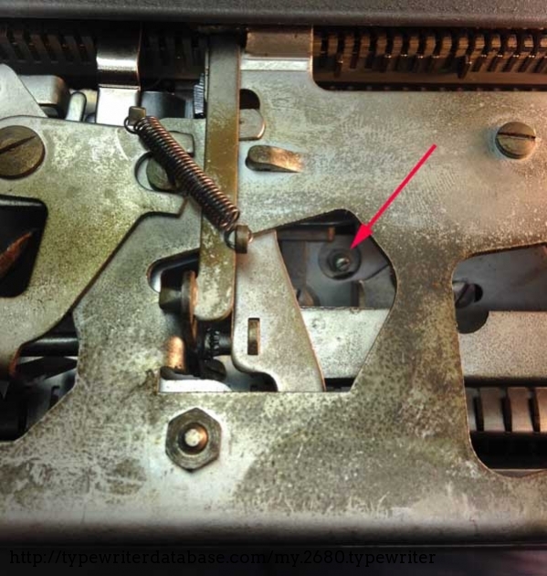 View of the back of the typewriter, with panel off. Turning this screw counterclockwise fixed the skipping problem. Get access to the retaining nut by slipping needlenose pliers through the bottom of the machine.