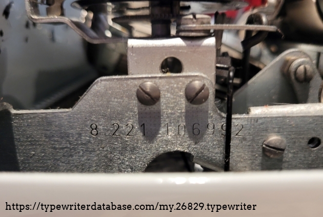 Remove the ribbon cover to find the serial number along the inner right edge, facing out.