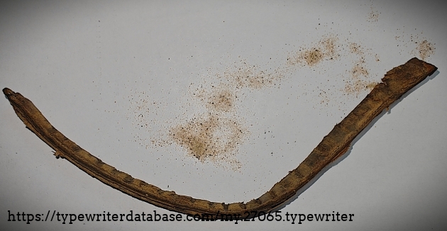 Old front typebar rest.  It seems to be a sewn leather tube filled with granular sand.  The sand is spilling out.